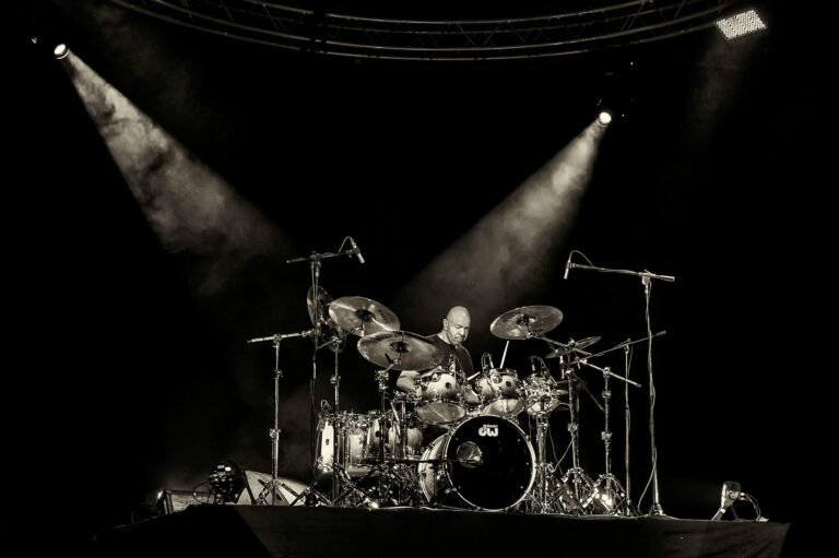 Dynamic concert scene with a drummer rocking on stage under spotlights in San Salvador.